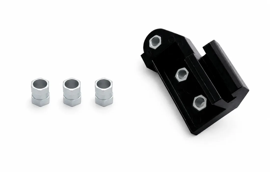 Black nylon bracket molded around three metal inserts, with three loose inserts beside it